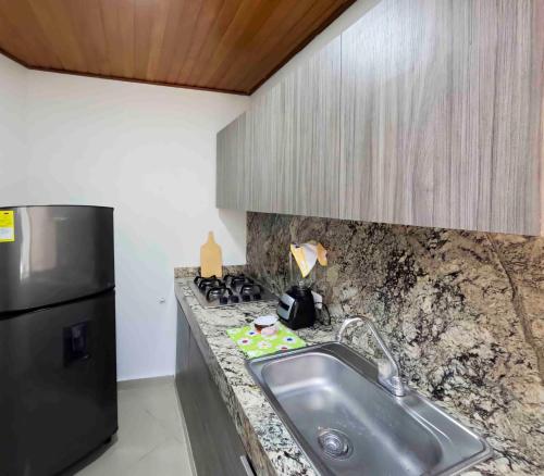 a kitchen with a sink and a refrigerator at casa javi in Santa Marta