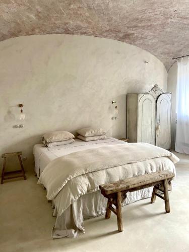 a bedroom with a large bed and a bench at La Saracina in Pienza