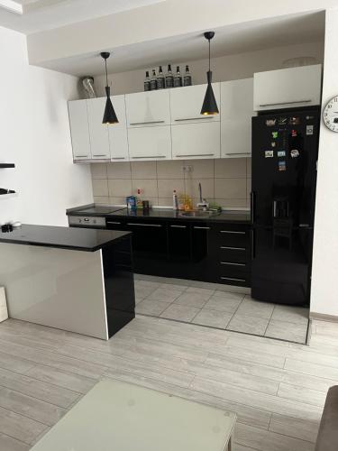 una cucina con frigorifero nero e armadietti bianchi di Apartment studio a Konjic