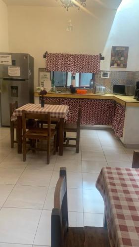 a dining room with a table and a kitchen at Casa Tequio in San Cristóbal de Las Casas