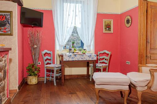 a dining room with red walls and a table and chairs at Apartma Casa della Pizza - Parking included in Izola