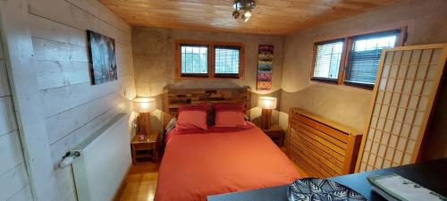 une chambre avec un lit dans une pièce avec des fenêtres dans l'établissement studio des dents de lanfon, à Écharvine