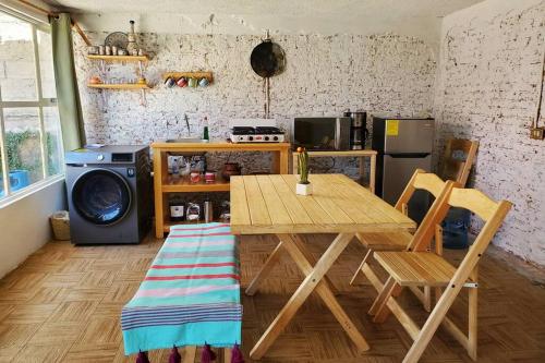 a kitchen with a table and a washing machine at JocoHideaway in Jocotitlán