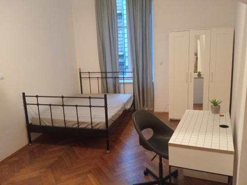 um quarto com uma cama, uma secretária e uma mesa em Apartament Batorego em Cracóvia