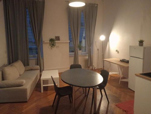 uma sala de estar com uma mesa e um sofá em Apartament Batorego em Cracóvia