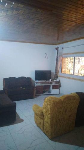 a living room with a couch and a television at villa yaoundé in Yaoundé
