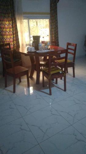 una sala da pranzo con tavolo e 4 sedie di villa yaoundé a Yaoundé