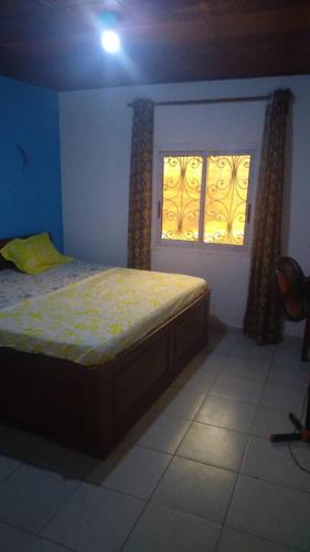 una camera con un letto e due finestre di villa yaoundé a Yaoundé