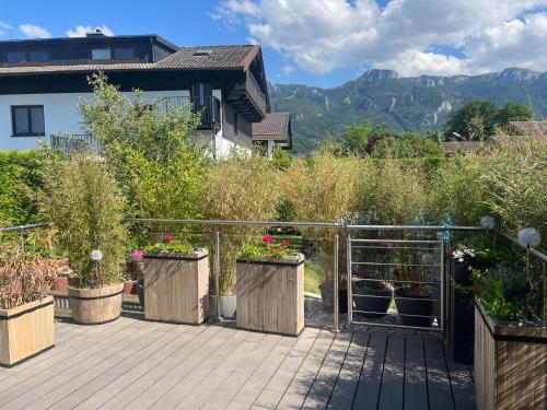 a wooden deck with potted plants and a house at ciao-aschau FeWo Lexa in Aschau