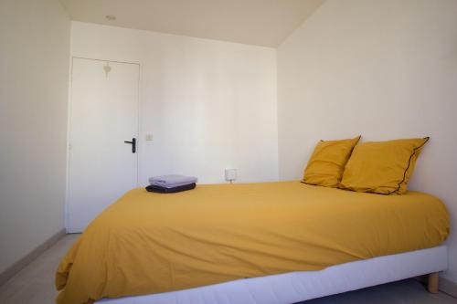 1 dormitorio con 1 cama grande con almohadas amarillas en Le grand bassin 10 min Disney 25 min Paris 11guests, en Lognes