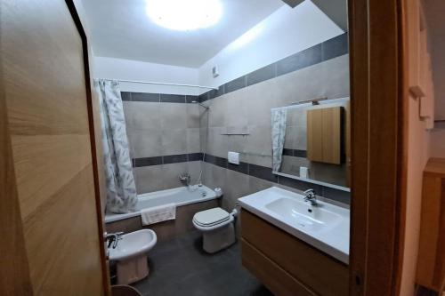 uma casa de banho com 2 lavatórios, um WC e um espelho. em Appartamento Le Vele em Fiumicino