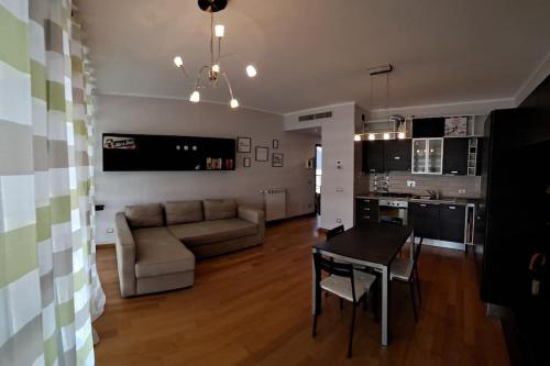 uma sala de estar com um sofá, uma mesa e uma cozinha em Appartamento Le Vele em Fiumicino