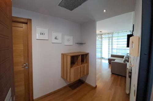 een woonkamer met witte muren en een houten kast bij Appartamento Le Vele in Fiumicino