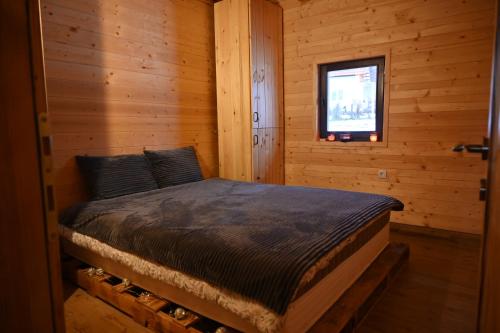 - une chambre avec un lit dans une cabane en rondins dans l'établissement Skroviste, Zlatibor-Vodice, à Zlatibor