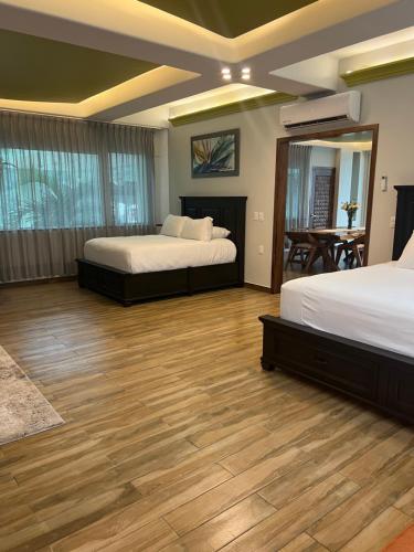 um quarto com 2 camas e piso em madeira em South Shore Villa Armonia Luxury Boutique em Puerto Vallarta