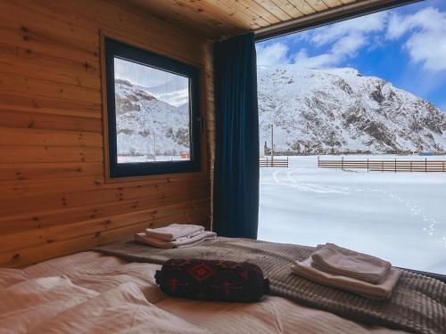 a bedroom with a bed and a window with snow covered mountains at Wildwood Kazbegi in Kazbegi
