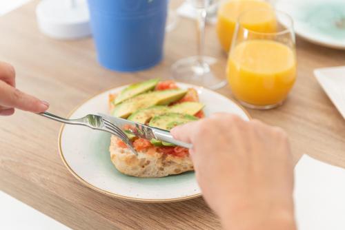 una persona che mangia un piatto di cibo su un tavolo di Villa Real Club Apartments a Camp de Mar