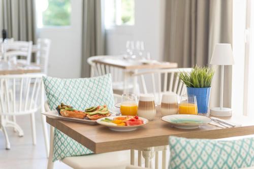 a table with a plate of food and glasses of orange juice at Villa Real Club Apartments in Camp de Mar