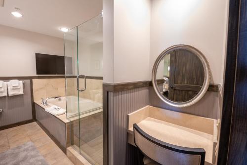 a bathroom with a tub and a sink and a mirror at The Lodge at Mountaineer Square in Mount Crested Butte