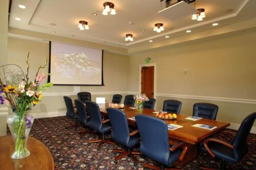 a conference room with a wooden table and chairs at The Lodge at Mountaineer Square in Mount Crested Butte