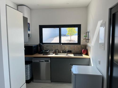 a small kitchen with a sink and a window at Quinta Ria Formosa in Olhão