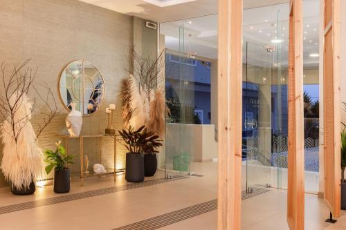 a lobby with potted plants and a mirror at Kalamaki Beach Hotel, Zakynthos Island in Kalamaki