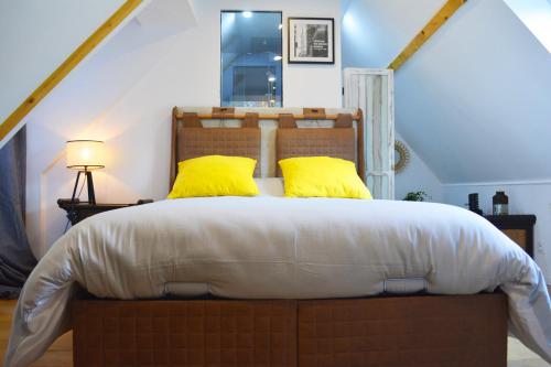 una camera da letto con un grande letto con cuscini gialli di Manoir Drissia - Tours Centre, France a Saint-Avertin