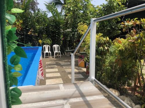 a stairway with two white chairs and a pool at Cabinas Ole Caribe in Puerto Viejo