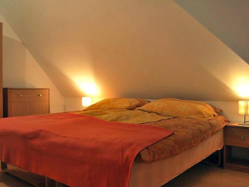 a bed in a room with two lamps and a bedvisor at Wynajem willi z 3 sypialniami Sasino, in Sasino