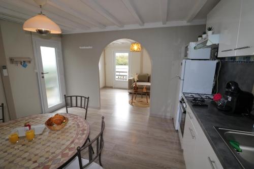 une cuisine et une salle à manger avec une table et une cuisine gmaxwell gmaxwell gmaxwell dans l'établissement Chalet au bord de l eau, à Rochefort-sur-Nenon
