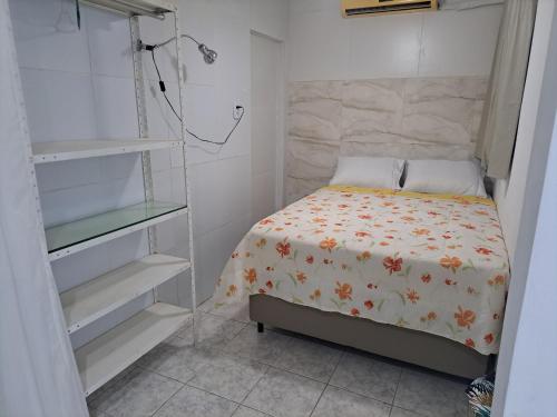 a small bedroom with a bed and shelves at Aconchegante Apto de 1qt a 60mts do Consulado EUA in Recife