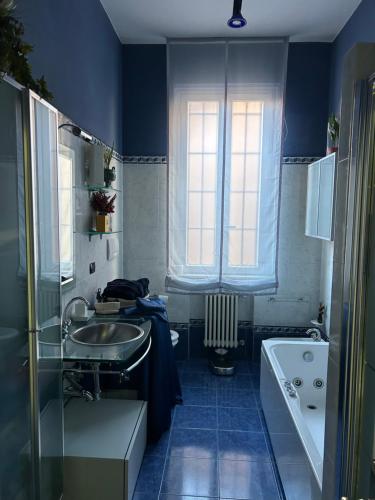 a blue bathroom with a sink and a window at Il villino della duchessa in Parma