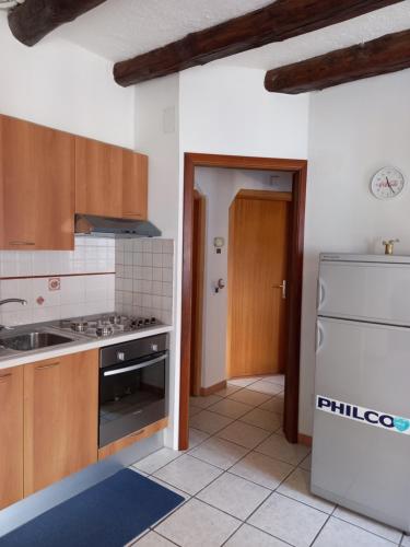 a kitchen with a stove and a refrigerator at Appartamento 'Io e te' in Pieve dʼAlpago