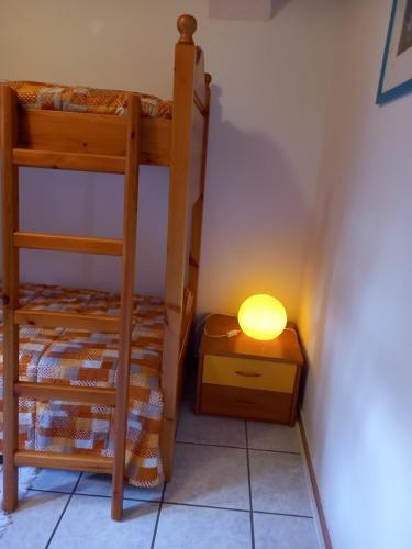 a lamp on a night stand next to a bunk bed at Appartamento 'Io e te' in Pieve dʼAlpago