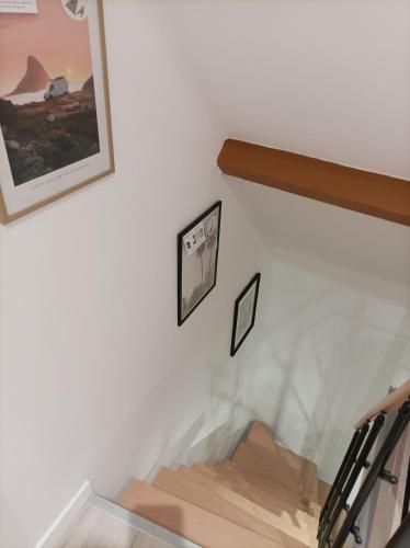 a staircase with two pictures on a white wall at L Imperial 6 -CentreVille- WIFI in Étampes