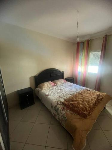 une chambre avec un lit avec une couverture dessus dans l'établissement Appartement in Mohammedia, à Mohammedia