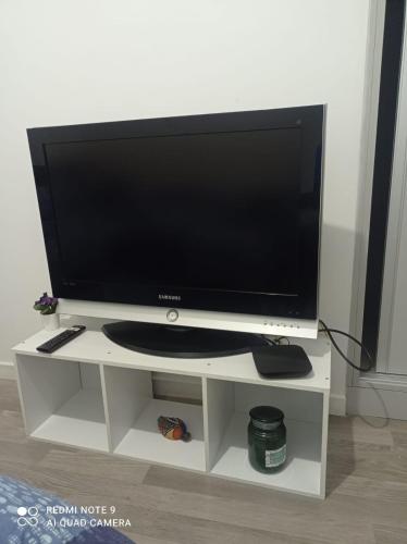 - une télévision à écran plat sur un centre de divertissement blanc dans l'établissement Blessing, à Rosny-sous-Bois