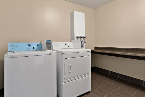 a laundry room with two machines and a counter at Quality Inn Memphis Northeast near I-40 in Memphis