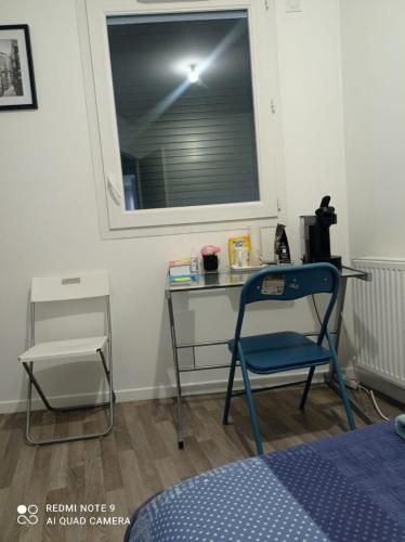 Cette chambre dispose d'un bureau et d'une chaise. dans l'établissement Blessing, à Rosny-sous-Bois