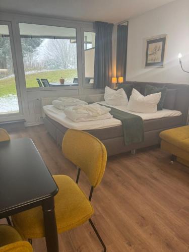 a hotel room with a bed and chairs and a table at Stressless aktivCARD Bayerischer Wald inklusive in Sankt Englmar