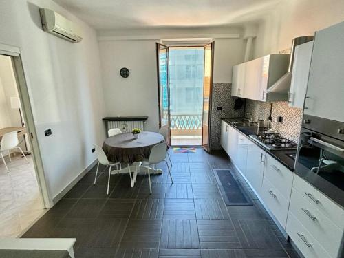 a kitchen with white cabinets and a table with chairs at Milano Flat - Primaticcio in Milan