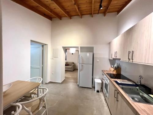 a kitchen with a table and a refrigerator at The Courtyard Episkopi Guest Houses in Episkopi Limassol