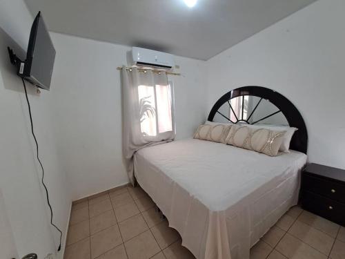 Dormitorio pequeño con cama y TV en casa familiar san miguel, en San Miguel