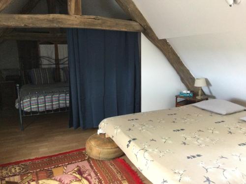 a bedroom with a bed with a blue curtain at Nuitées au calme de la campagne bourbonnaise in Paray-sous-Brailles