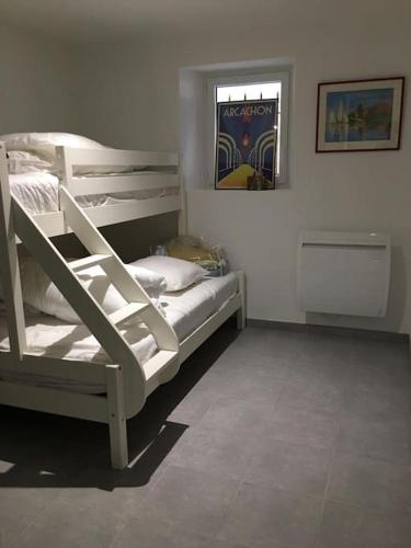 une chambre avec deux lits superposés et une fenêtre dans l'établissement Appartement 2 chambres avec jardinet privatif - 200m de la plage Pereire, à Arcachon