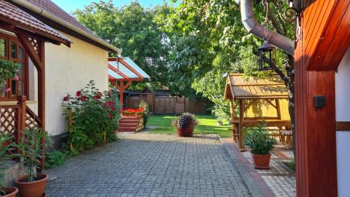 un jardín con una pasarela de ladrillo junto a una casa en Old House Bogacs, en Bogács