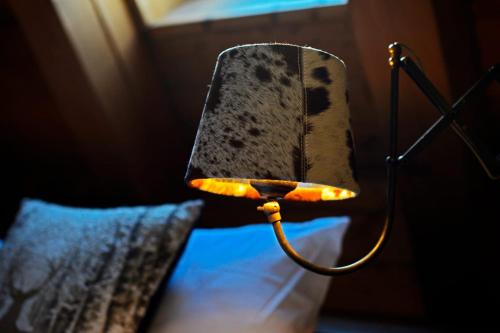 a lamp on the side of a bed with a pillow at L'Ame du Mont Blanc in Pré-Saint-Didier