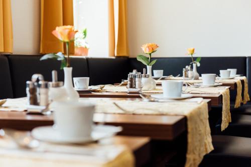 a dining room with wooden tables with flowers on them at Arcade Hotel in Wuppertal