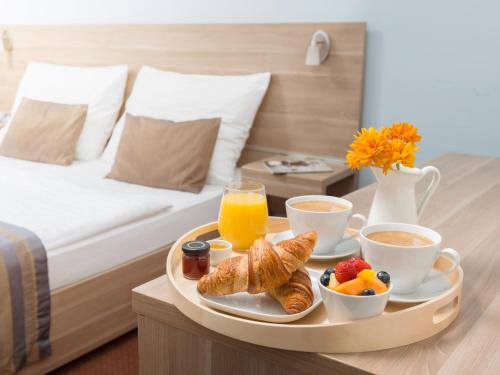 a tray of breakfast food on a table in a hotel room at SCN City Hotel Rayong in Ban Chang