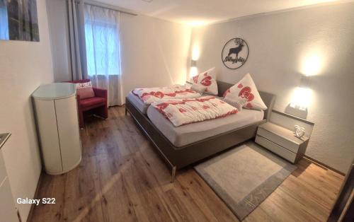 1 dormitorio pequeño con 1 cama y 1 silla en Ferienwohnung Alpenherz, en Obermaiselstein